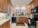 Kitchen with wood cabinets, black appliances, and a view to the living area at 760 Village Cir # 212, Venice, FL 34292