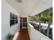 View of condo exterior with covered walkway, lush landscaping, and parking at 760 Village Cir # 212, Venice, FL 34292