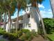 Two-story condo building with lush landscaping and palm trees at 760 Village Cir # 212, Venice, FL 34292