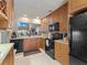 Kitchen with wood cabinets, black appliances, and ample counter space at 760 Village Cir # 212, Venice, FL 34292