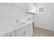 Laundry room with white cabinets, sink, and shelving at 18260 Vizcaya Ct, Venice, FL 34293