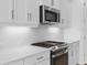Modern kitchen with white cabinets, quartz countertops, and stainless steel appliances at 18260 Vizcaya Ct, Venice, FL 34293