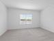 Bright bedroom with neutral carpeting and a large window at 18260 Vizcaya Ct, Venice, FL 34293