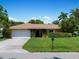 Ranch-style home with a two-car garage and lush lawn at 424 Baycrest Dr, Venice, FL 34285