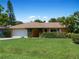 Ranch style home with a large yard, lush green grass, and mature landscaping at 424 Baycrest Dr, Venice, FL 34285