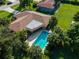 Aerial view of a home with a refreshing blue swimming pool and tropical landscaping at 424 Baycrest Dr, Venice, FL 34285