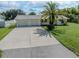 Front view of a single-story home with a two-car garage and a spacious driveway at 605 Barnes Pkwy, Nokomis, FL 34275