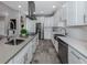 Modern kitchen with white cabinets, stainless steel appliances, and farmhouse sink at 2585 Hobblebrush Dr, North Port, FL 34289