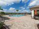 Community pool with lounge chairs, umbrellas, and a covered seating area at 2585 Hobblebrush Dr, North Port, FL 34289
