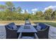 Cozy patio seating area with fire pit table and comfortable wicker chairs at 2585 Hobblebrush Dr, North Port, FL 34289