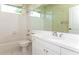 Clean bathroom with white vanity, tub, and toilet; features decorative wallpaper at 653 Crossfield Cir # 8, Venice, FL 34293