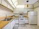 Kitchen with white cabinets, double sink and stove at 886 Bird Bay Way # 206, Venice, FL 34285