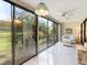 Bright sunroom with sliding glass doors leading to a deck and lush garden views at 886 Bird Bay Way # 206, Venice, FL 34285