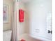 Clean bathroom with white tiled walls, tub and coral towels at 618 Bird Bay S Dr # 202, Venice, FL 34285