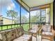 Relaxing lanai with wicker furniture and view of the grounds at 618 Bird Bay S Dr # 202, Venice, FL 34285