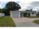 White single story home with gray roof, attached garage, and a well-manicured lawn at 205 Venice East Blvd, Venice, FL 34293