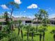 Backyard view of condo with lush landscaping and palm trees at 4260 Placida Rd # 13B, Englewood, FL 34224