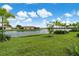 Landscaped backyard with serene lake view and lush greenery at 240 Teramo Way, Nokomis, FL 34275