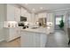 Modern kitchen with white cabinets, quartz countertops, and stainless steel appliances at 240 Teramo Way, Nokomis, FL 34275