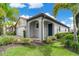 Single-story house with a dark front door, grey exterior, and landscaping at 240 Teramo Way, Nokomis, FL 34275