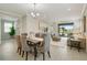 Open concept dining area with wood table and gray chairs at 240 Teramo Way, Nokomis, FL 34275