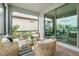Peaceful screened patio with wicker furniture and lake view at 240 Teramo Way, Nokomis, FL 34275