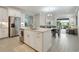 Open concept kitchen with white cabinets, island, and stainless steel appliances at 240 Teramo Way, Nokomis, FL 34275