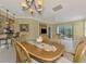 Bright dining room with wood table and chairs, view of patio at 1780 Batello Dr, Venice, FL 34292