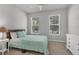 Serene bedroom with light teal bedding and two windows at 20318 Minuet Pl, Venice, FL 34293