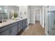 Modern bathroom with double vanity, walk-in shower, and grey cabinets at 20318 Minuet Pl, Venice, FL 34293