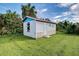 White storage shed with pink roof in grassy backyard at 8430 Roosevelt St, Englewood, FL 34224