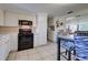 Full kitchen with white cabinets, black appliances and breakfast nook at 8430 Roosevelt St, Englewood, FL 34224