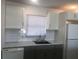 Bright kitchen with white cabinets, gray lower cabinets, and a clean backsplash at 268 Shamrock Blvd, Venice, FL 34293