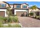 Two-story townhome with brown garage doors and a brick driveway at 12460 Ghiberti Cir # 202, Venice, FL 34293