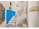 Modern staircase with a blue accent wall and wood railing at 12460 Ghiberti Cir # 202, Venice, FL 34293