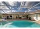 Large screened pool with fountain and view of the home's patio at 466 Lake Of The Woods Dr, Venice, FL 34293