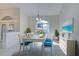 Charming dining room with white table and blue chairs at 466 Lake Of The Woods Dr, Venice, FL 34293