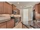 Kitchen featuring stainless steel appliances, granite counters, and rich wood cabinets at 12273 Stuart Dr, Venice, FL 34293