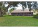 Expansive backyard showing the covered lanai, lush lawn, and mature trees at 217 Carriage House Ln # 217, Nokomis, FL 34275