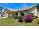 Well-maintained single-story home with a tile roof, arched entryway, and vibrant landscaping at 217 Carriage House Ln # 217, Nokomis, FL 34275