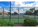 View of the community tennis courts behind fencing with surrounding trees and shrubbery at 217 Carriage House Ln # 217, Nokomis, FL 34275