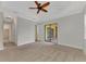 Bright bedroom with ceiling fan, carpet, and access to bathroom and patio at 25134 Spartina Dr, Venice, FL 34293