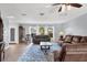 Bright living room features hardwood floors, modern ceiling fan, and comfortable brown leather furniture at 412 Rubens Dr, Nokomis, FL 34275