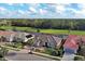 Aerial view of a home with a tile roof, green lawn, and serene water and golf course views at 594 Sawgrass Bridge Rd, Venice, FL 34292