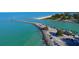 Stunning aerial view of the coastline, with clear blue water, a sandy beach, and coastal parking areas at 594 Sawgrass Bridge Rd, Venice, FL 34292