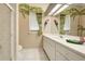 Bathroom featuring a double vanity with white cabinets, complemented by tropical-themed decor at 594 Sawgrass Bridge Rd, Venice, FL 34292