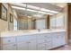 Bathroom featuring a double vanity with white cabinets, granite countertops, and a well-lit mirror at 594 Sawgrass Bridge Rd, Venice, FL 34292