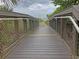 Wooden walkway through lush greenery, guiding visitors towards a tranquil beach with mesmerizing water views at 594 Sawgrass Bridge Rd, Venice, FL 34292