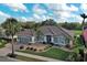 Beautiful single-story home with a brick driveway, well-maintained lawn, and mature palm trees at 594 Sawgrass Bridge Rd, Venice, FL 34292