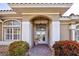 Elegant front entrance with arched doorway and manicured landscaping and brick pathway at 594 Sawgrass Bridge Rd, Venice, FL 34292